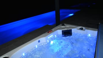 Un bain à remous doté d’un éclairage bleu, d’un panneau de commande et d’un écran numérique.