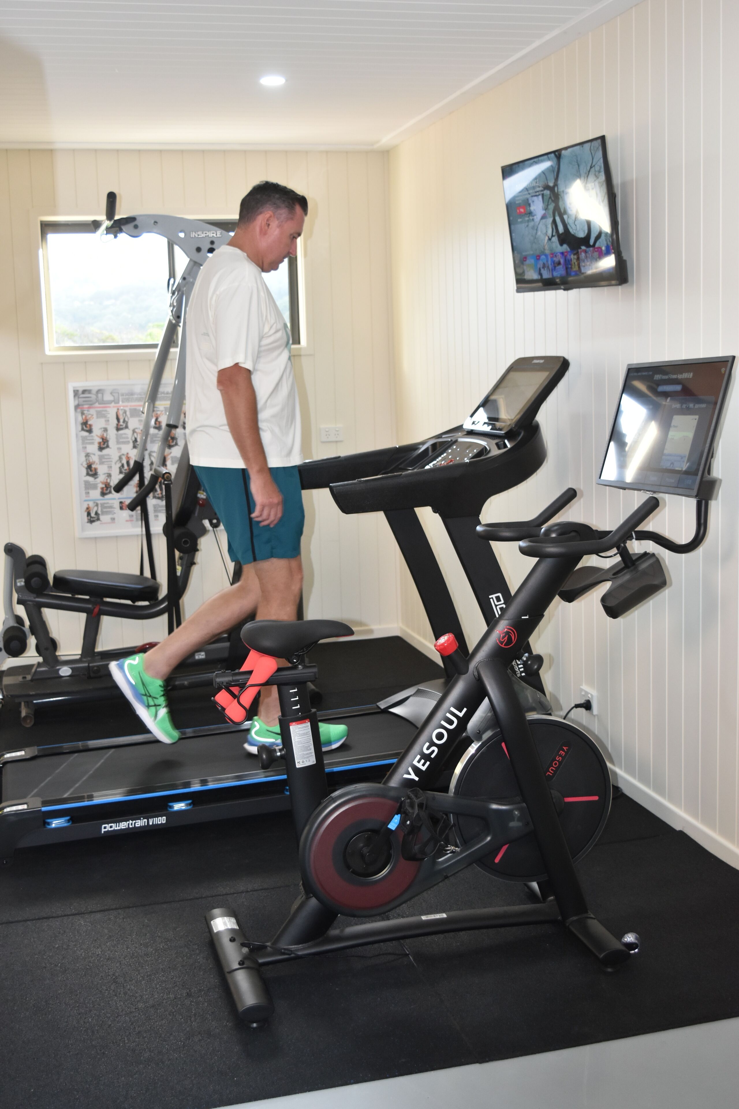 A gym with a treadmill, a stationary bike, and a weight bench.