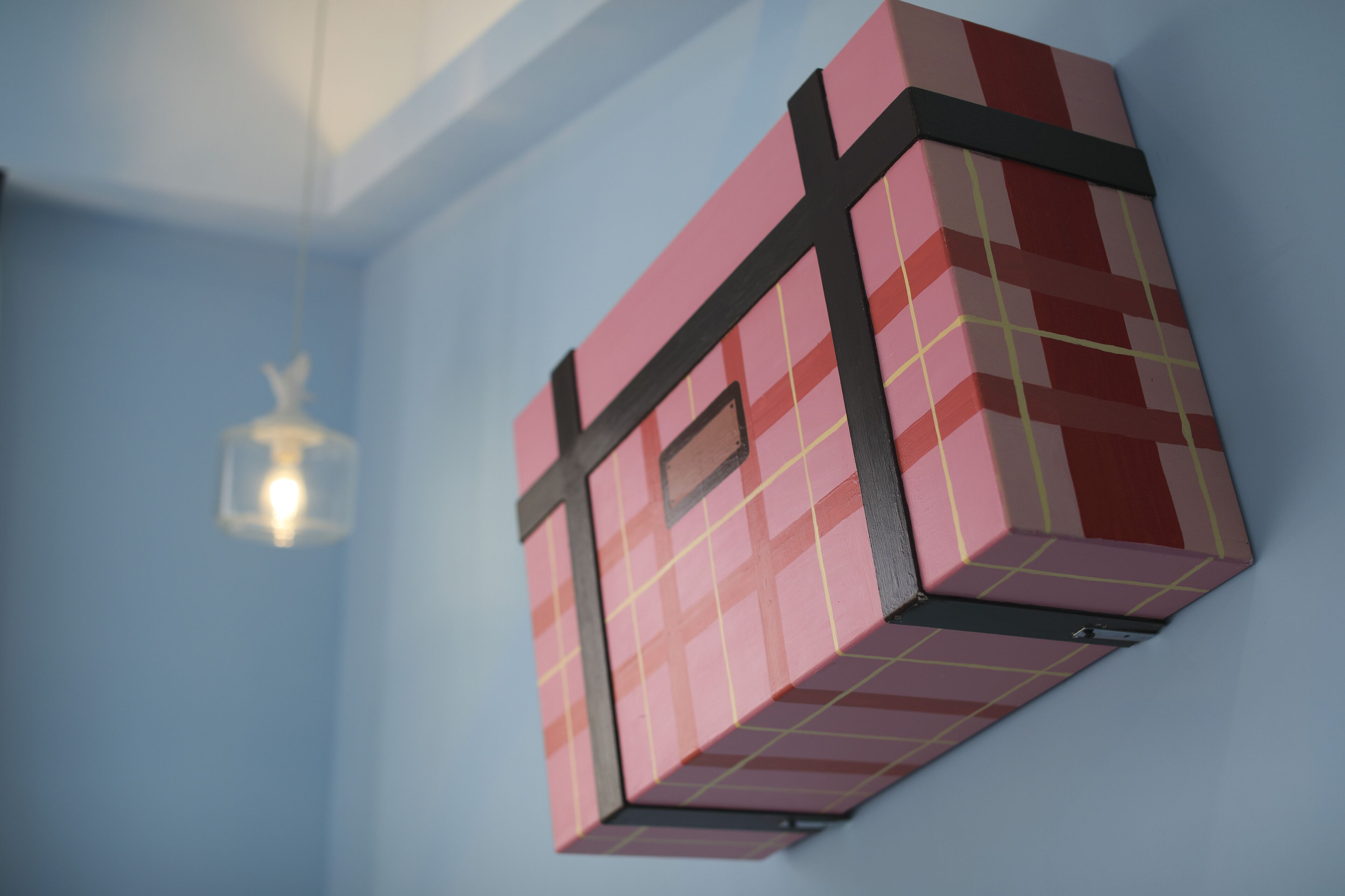Une pièce décorée d’une œuvre d’art géométrique sur le mur et d’un luminaire suspendu.