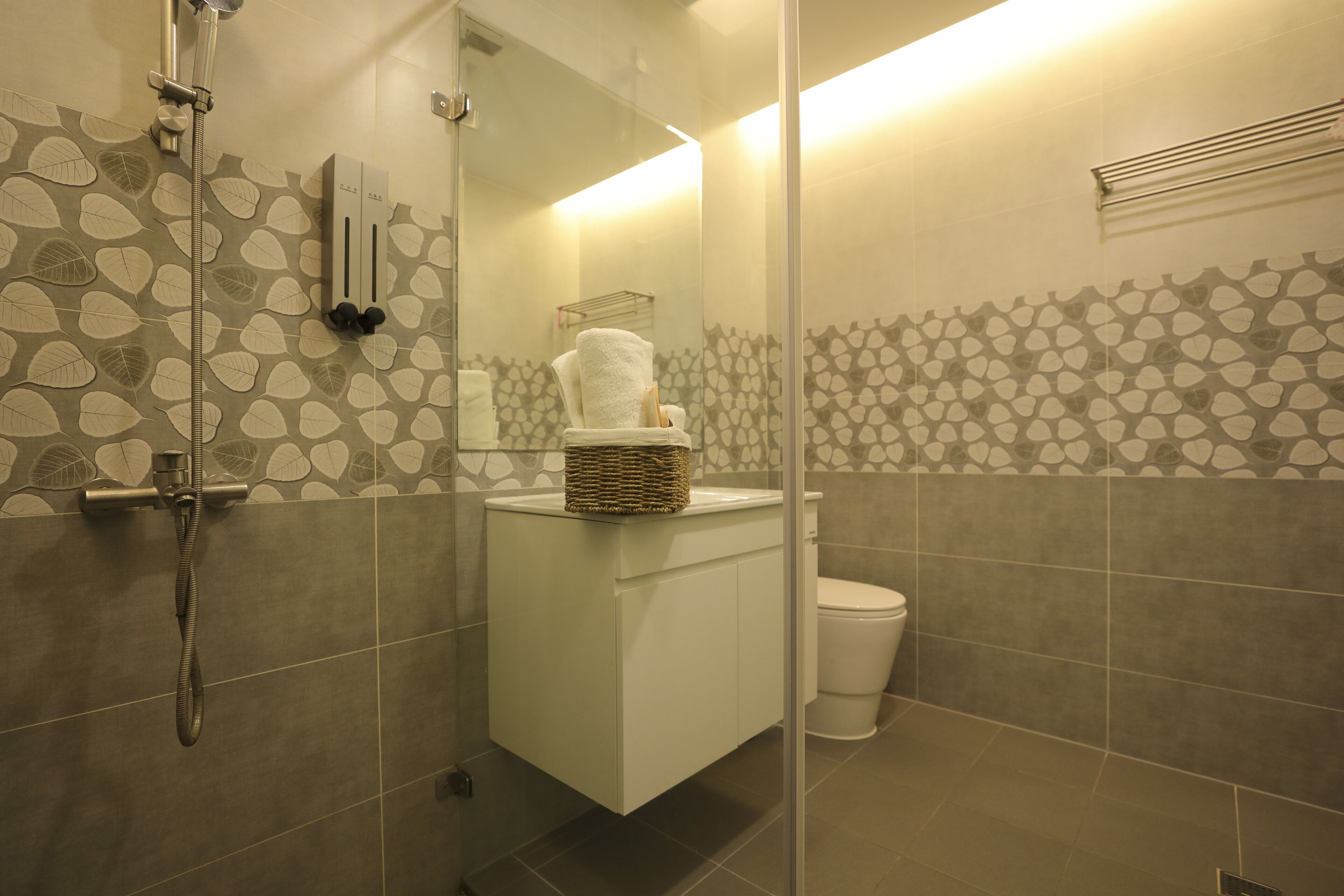 Ein Badezimmer mit Dusche, Toilette und Spiegel.