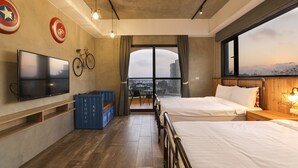 A modern hotel room with a large bed, a TV, a bicycle, and a view of the city through a large window. - Shiguang B&B (Magong)