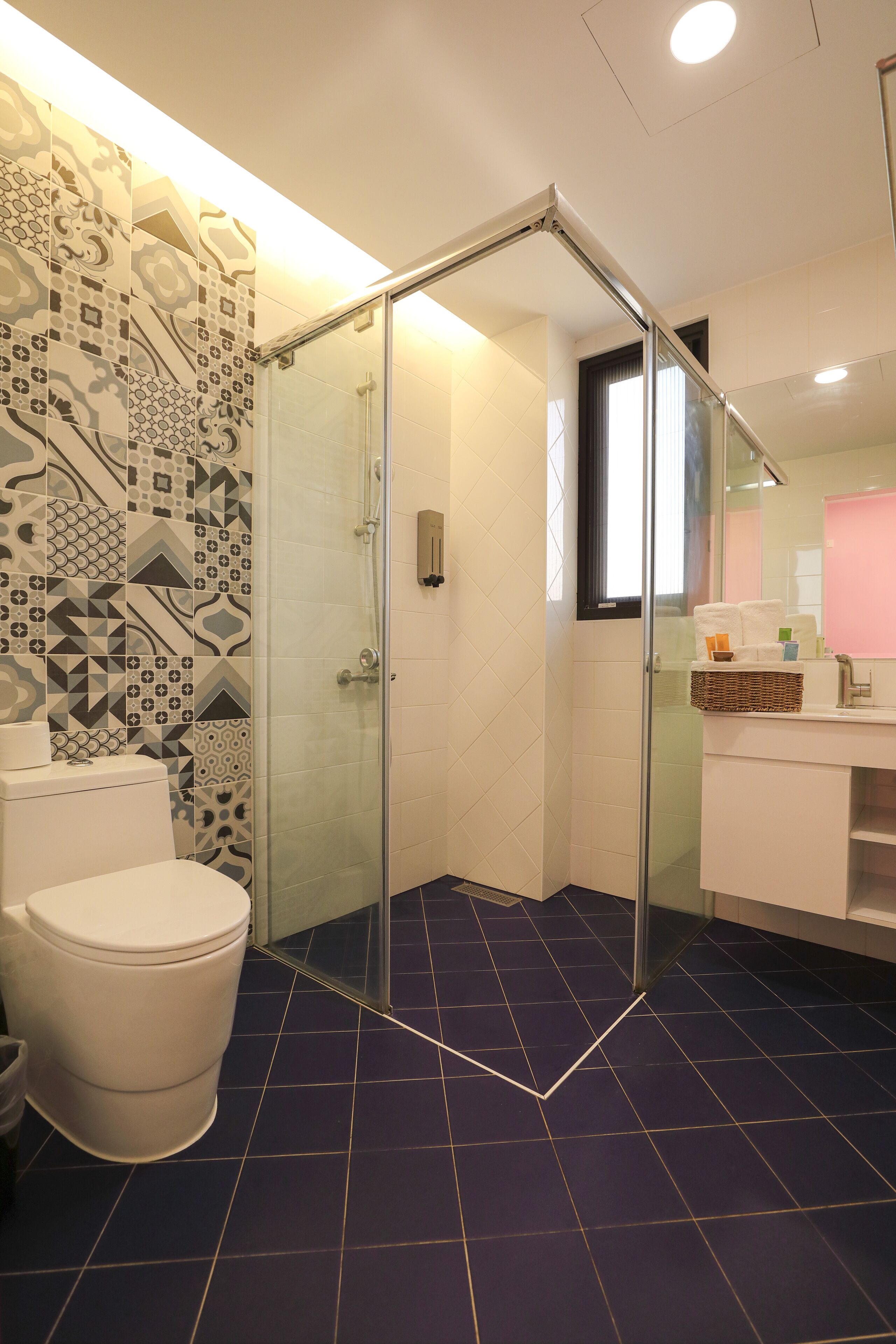 A bathroom with a shower, toilet, and sink.