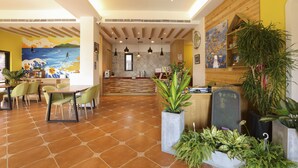 A spacious lobby with a tiled floor, a reception desk, and several potted plants. - Shiguang B&B (Magong)