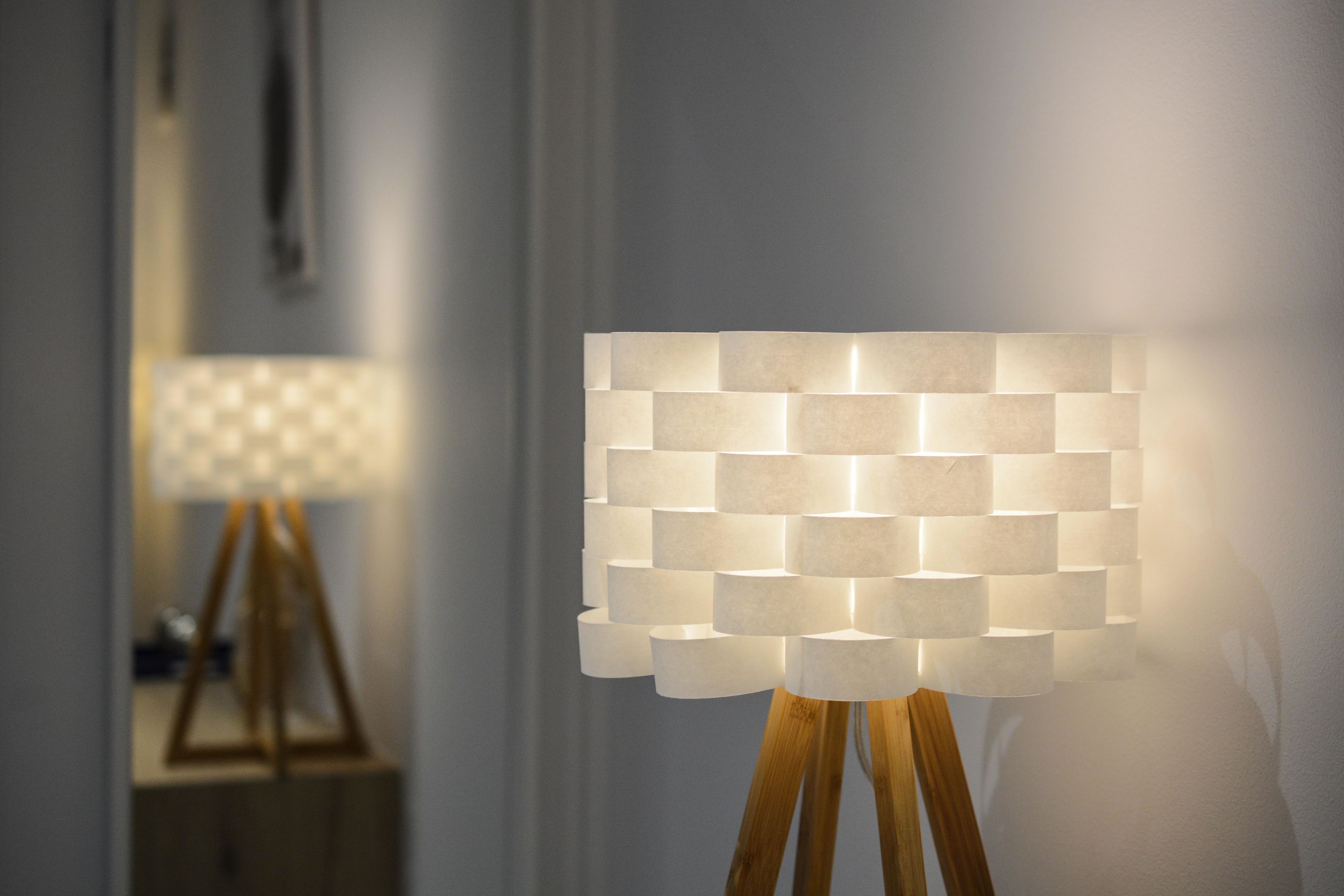 A lamp with a geometric pattern on a wooden stand.