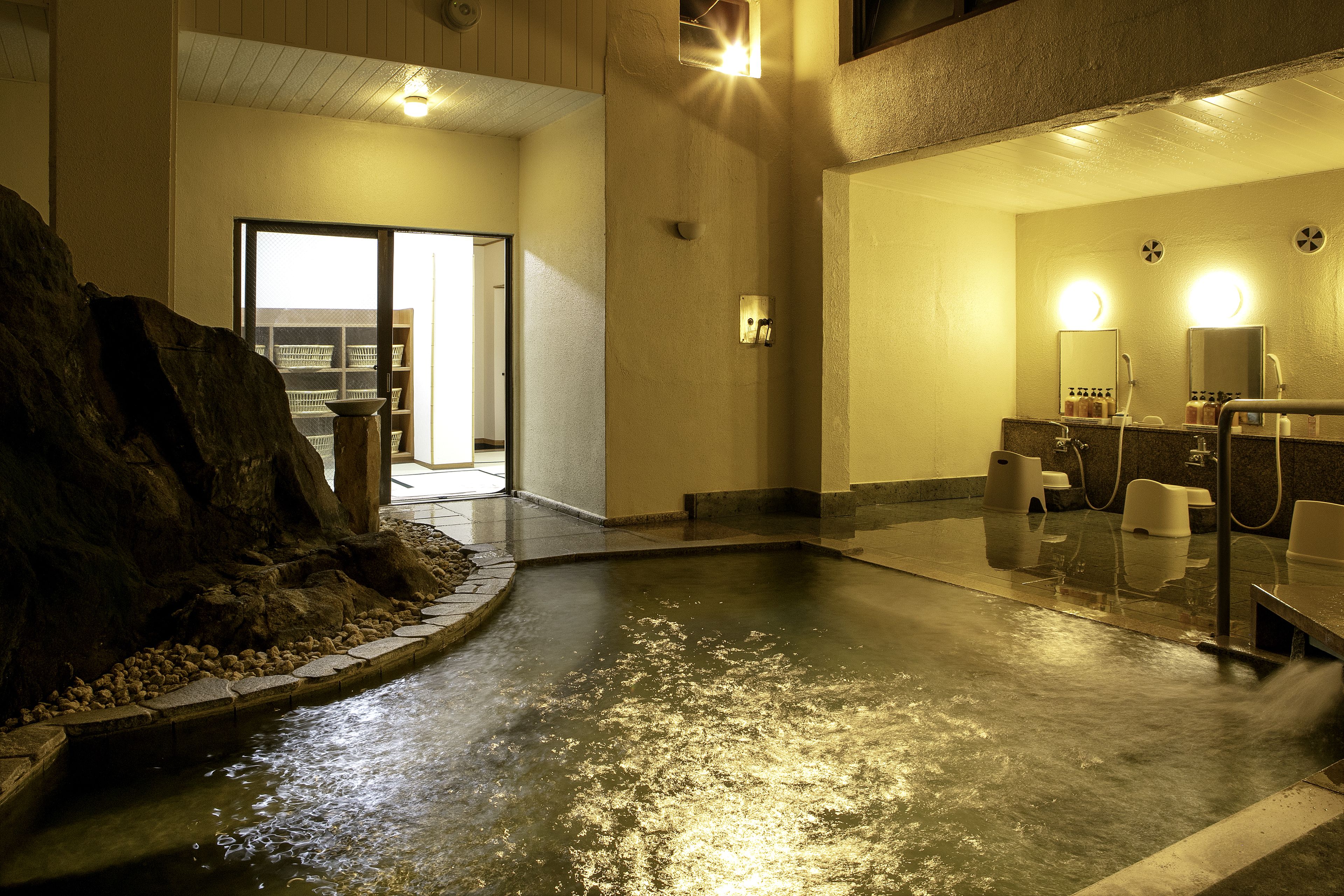 A spa area with a hot tub, seating area, and a mirror.