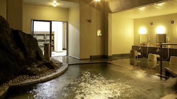 A spa area with a hot tub, seating area, and a mirror.
