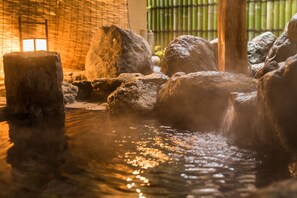 Un aménagement aquatique intérieur paisible, agrémenté de rochers et d’un décor de bambous.