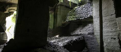 An underground passage with stone walls and a narrow, uneven path.