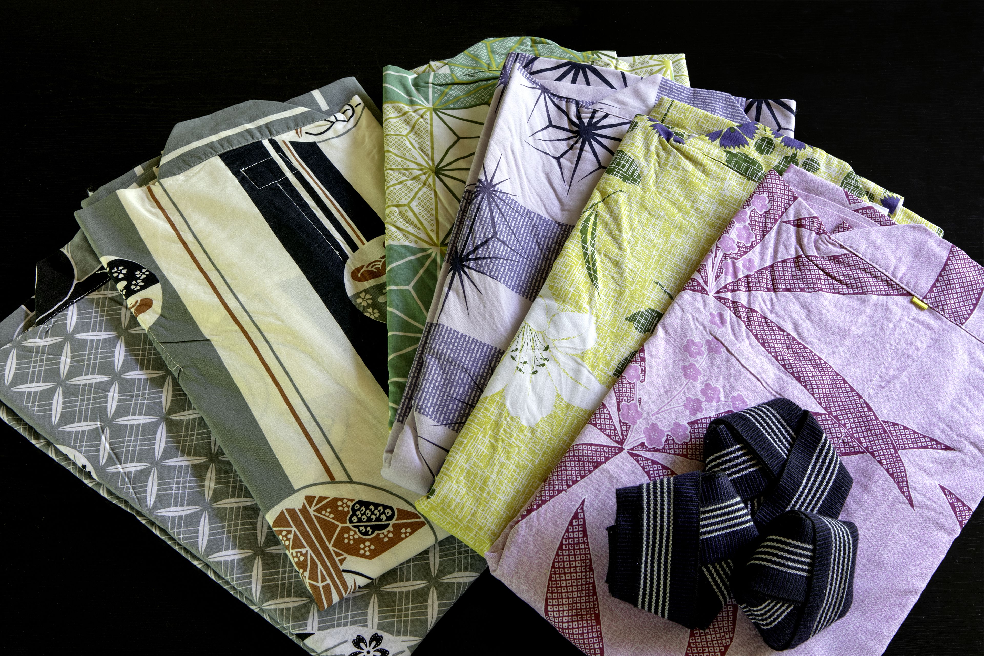 A collection of fabrics with various patterns and a bow.