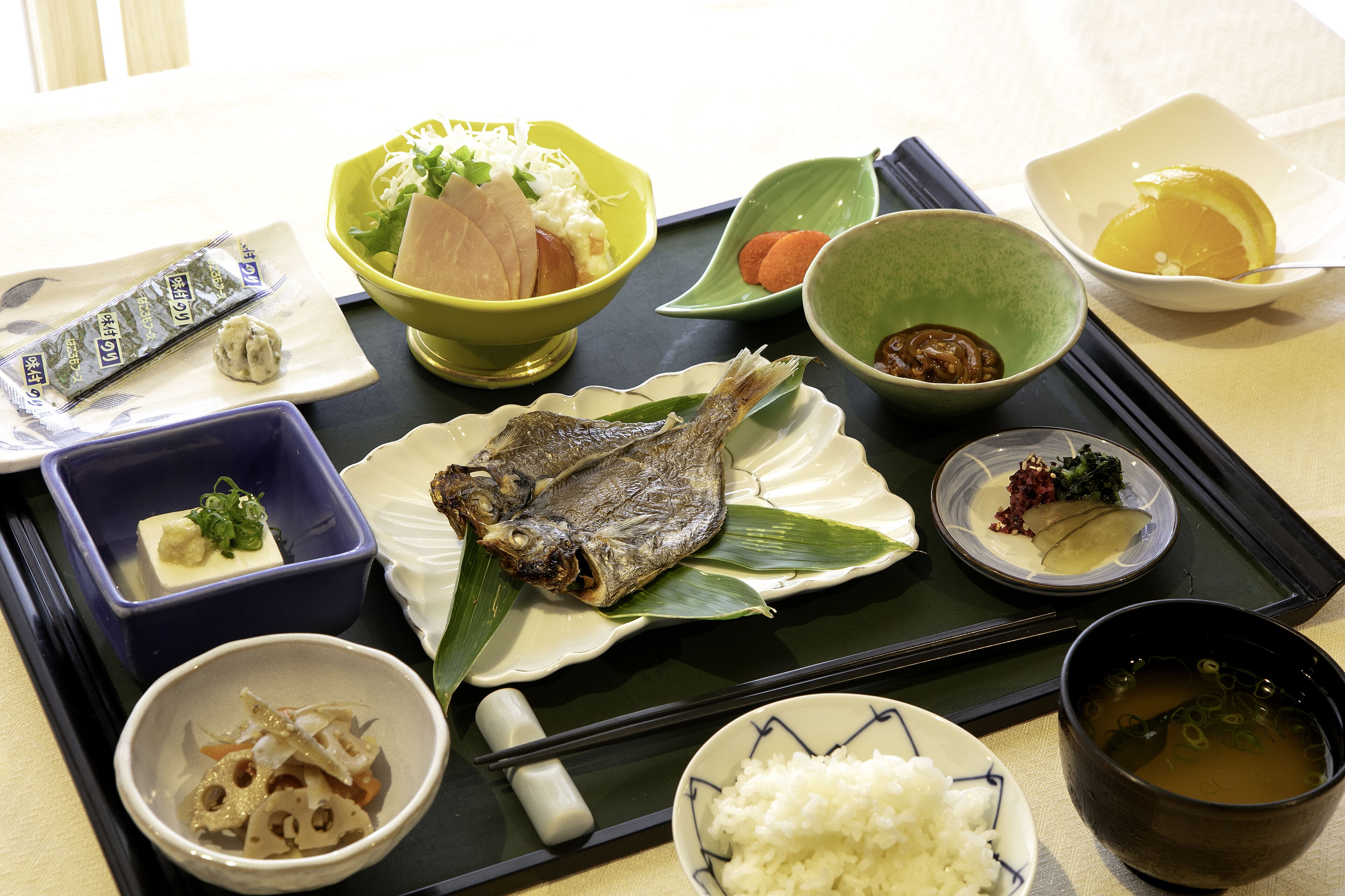 A tray with various dishes including fish, rice, and soup.