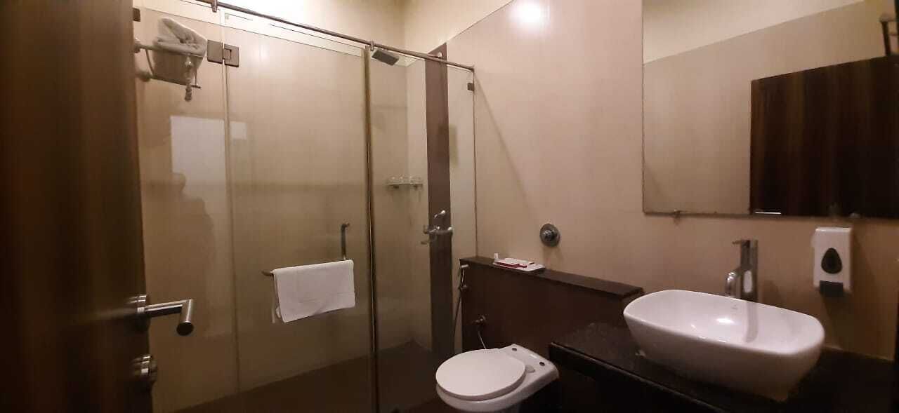 Une salle de bain moderne avec une douche à parois de verre, un lavabo blanc et des toilettes.