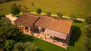 A large, two-story building with a tiled roof, surrounded by a well-maintained lawn and trees. - Agriturismo Le Cascatelle (Manciano)