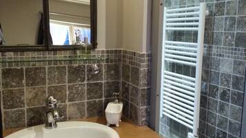 A bathroom with a white sink, a mirror, and a glass shower enclosure.