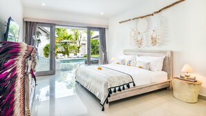 A spacious bedroom with a large bed, a view of a swimming pool, and a balcony. - Villa Maviba Seminyak (Seminyak)