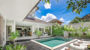 A pool area with lounge chairs and a dining area. - Villa Maviba Seminyak (Seminyak)