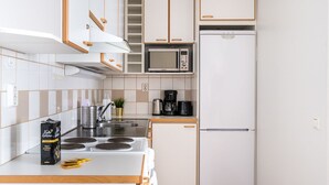 Una cocina compacta equipada con estufa, microondas y refrigerador.