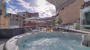 A rooftop swimming pool with a view of surrounding buildings and a clear sky. - athensotel (Athens)