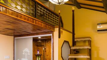 A traditional Japanese-style room with a wooden door, a shower, a decorative shelf, and a hanging light fixture.