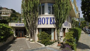 Un hotel amb un senyal ben visible que diu “HOTEL”, envoltat de cactus i plantes en testos.