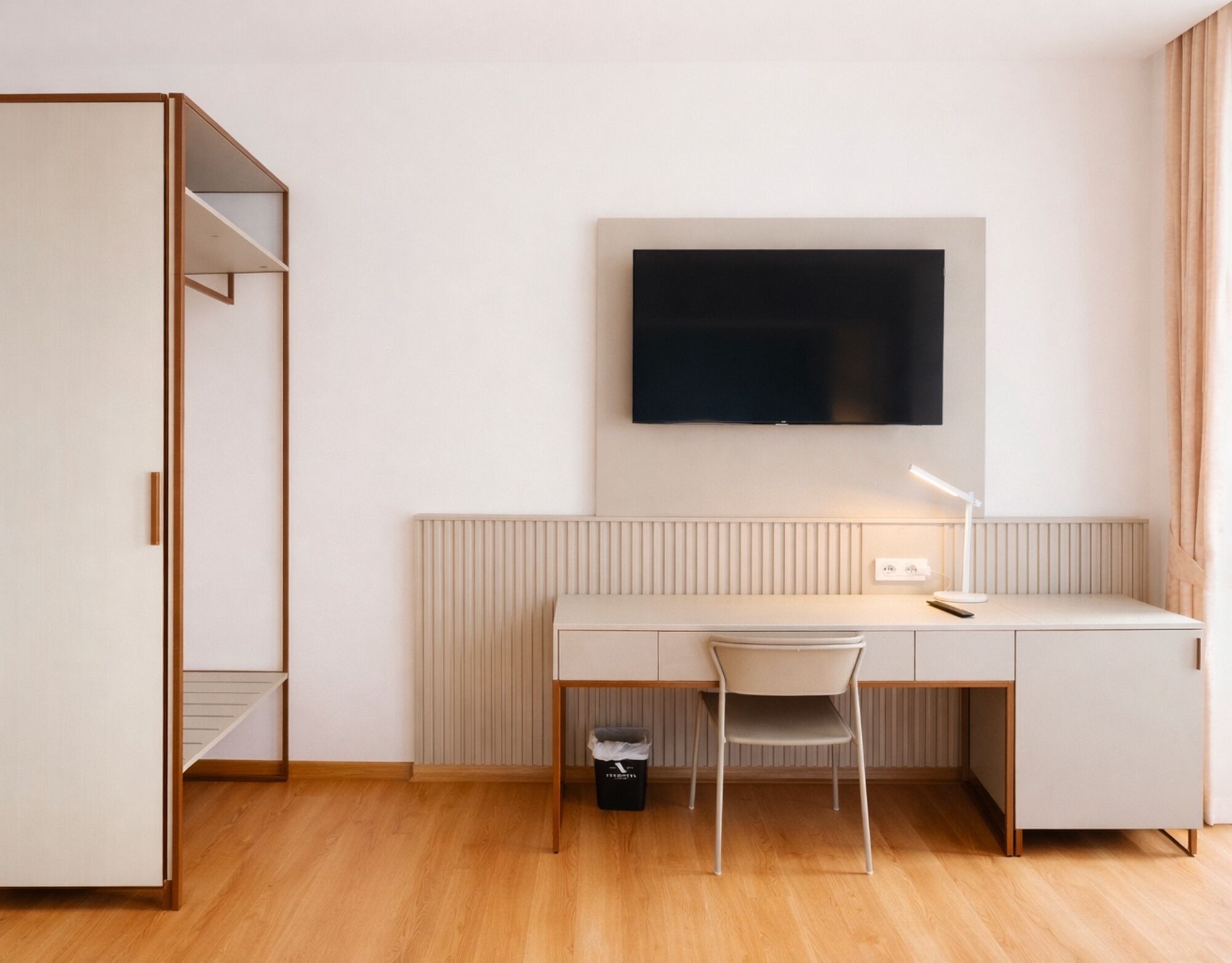 Une chambre à coucher moderne avec un lit, un bureau et un téléviseur.