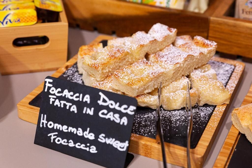 A display of focaccia dolce with a sign indicating it is homemade sweet focaccia.