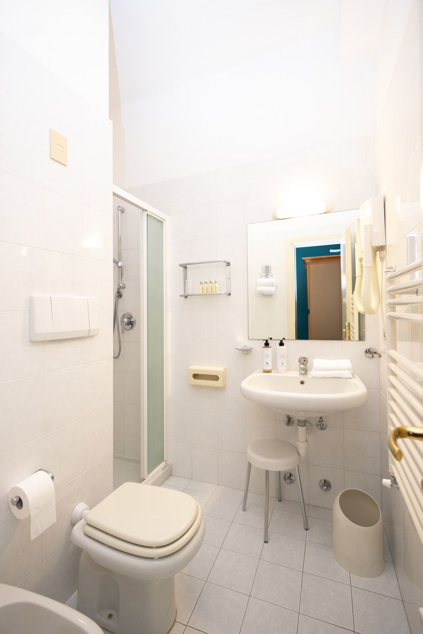 A modern bathroom with a toilet, sink, and shower.