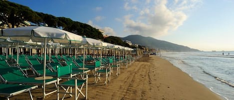 Ligstoelen aan het strand, parasols, strandlakens