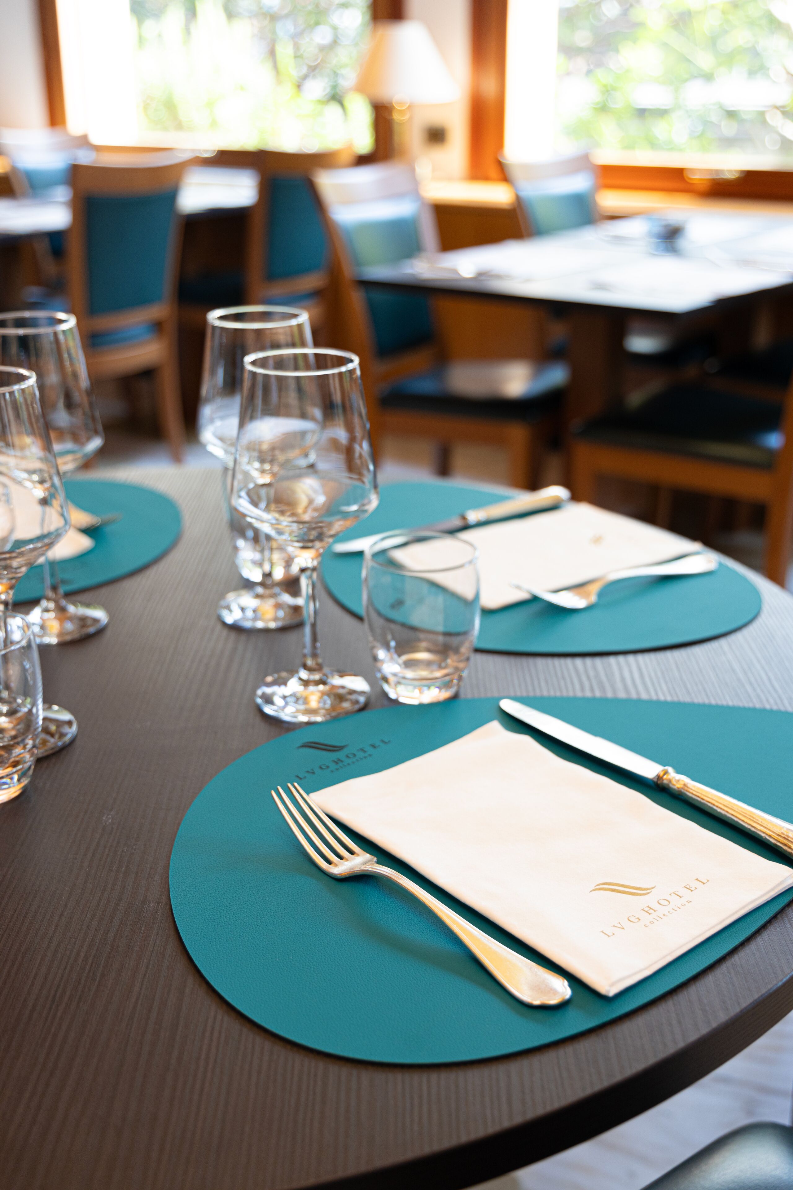 A table set for dining with a menu, glasses, and cutlery.