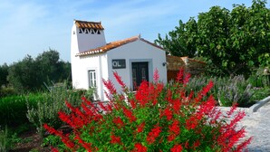 A white building with a tiled roof, a small tower, and a sign reading "QL". - Quinta das Lavandas (Castelo de Vide)