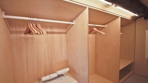 A wooden walk-in closet with hanging space and shelves. - Alfani Luxury Loft (Florence)