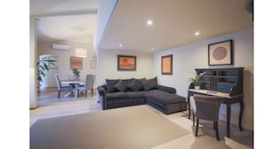 A modern living room with a sectional sofa, a dining table, and a small desk. - Alfani Luxury Loft (Florence)