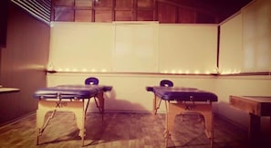 A room with two massage tables labeled 'Xie' and a whiteboard on the wall.