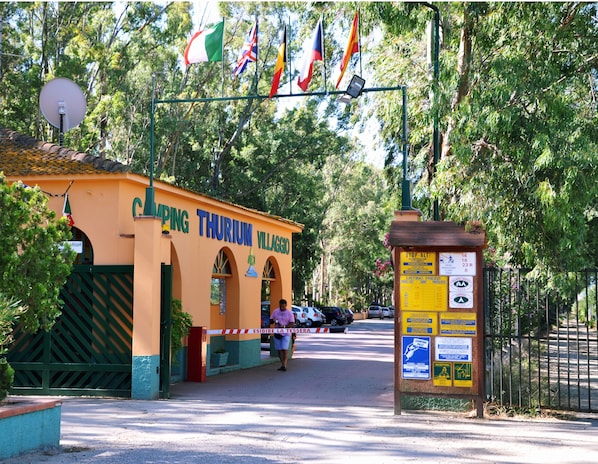 A building labeled "Camping Thurium Villaggio" with a signboard listing prices and amenities.
