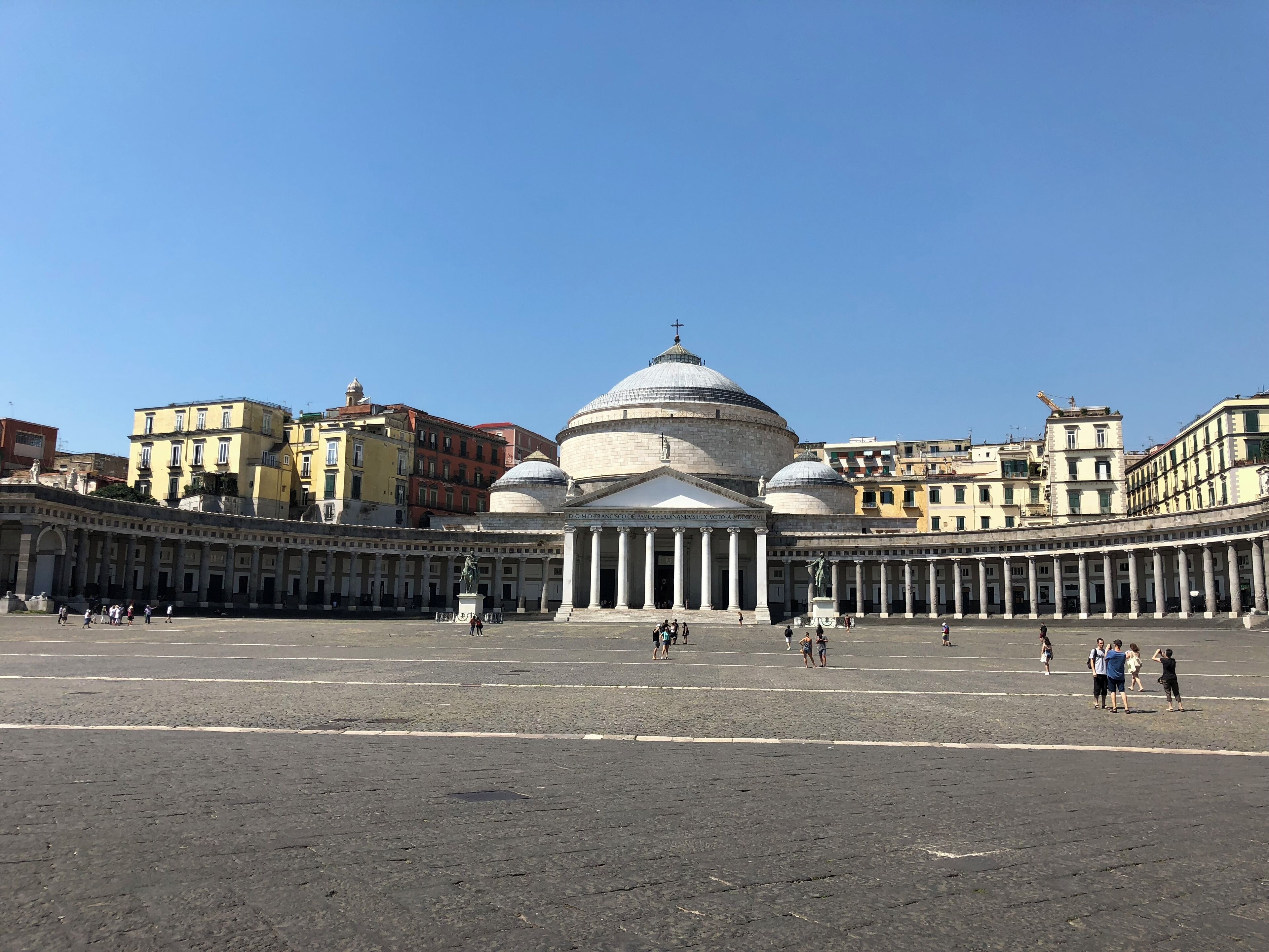 Un'ampia piazza aperta con un imponente edificio storico, caratterizzato da una cupola e colonne.