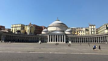 Un'ampia piazza aperta con un imponente edificio storico, caratterizzato da una cupola e colonne.