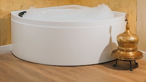 Ein modernes Badezimmer mit einer freistehenden Badewanne, einem goldenen Dekorationsgegenstand und Holzboden.