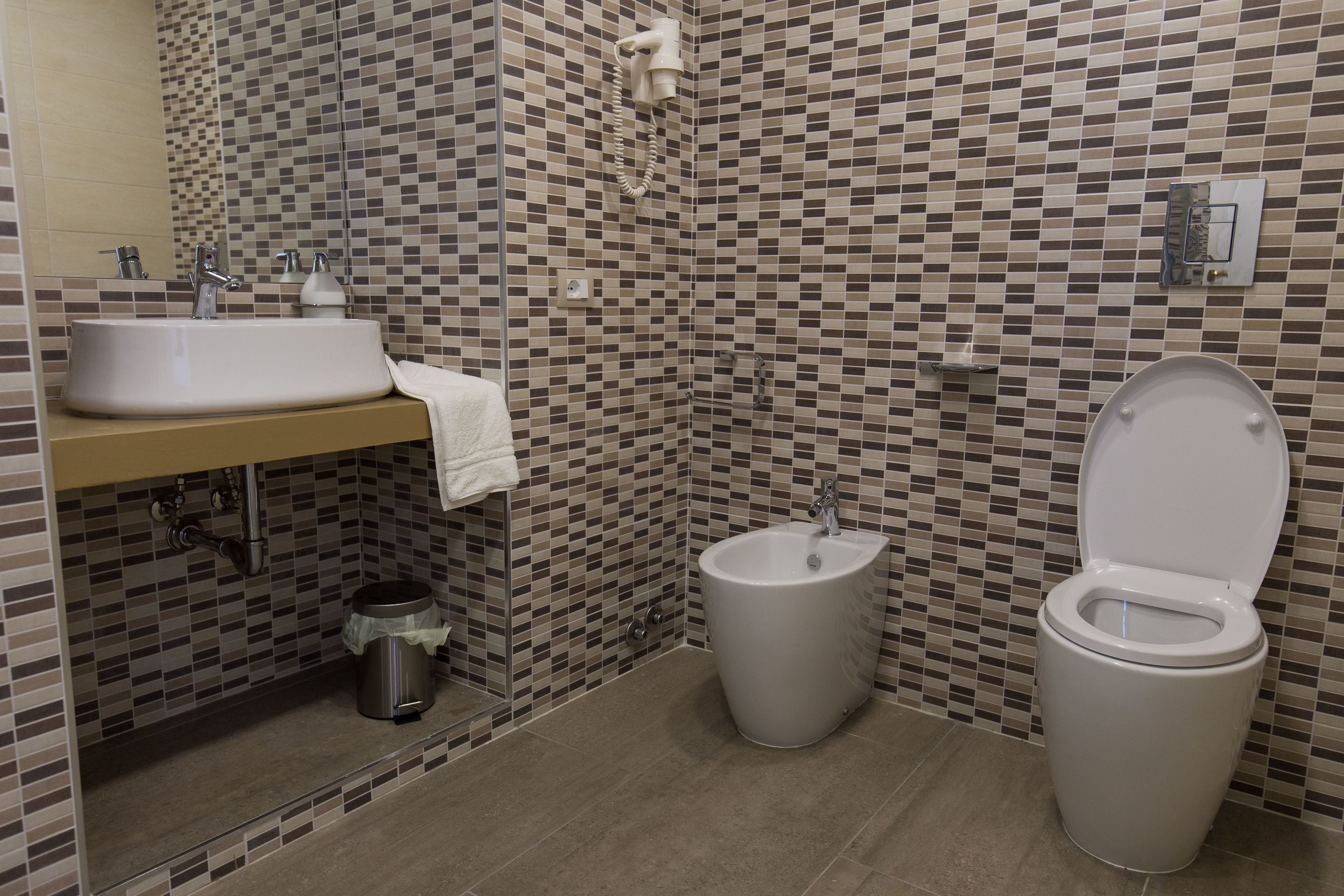 A bathroom with a sink, toilet, and shower.