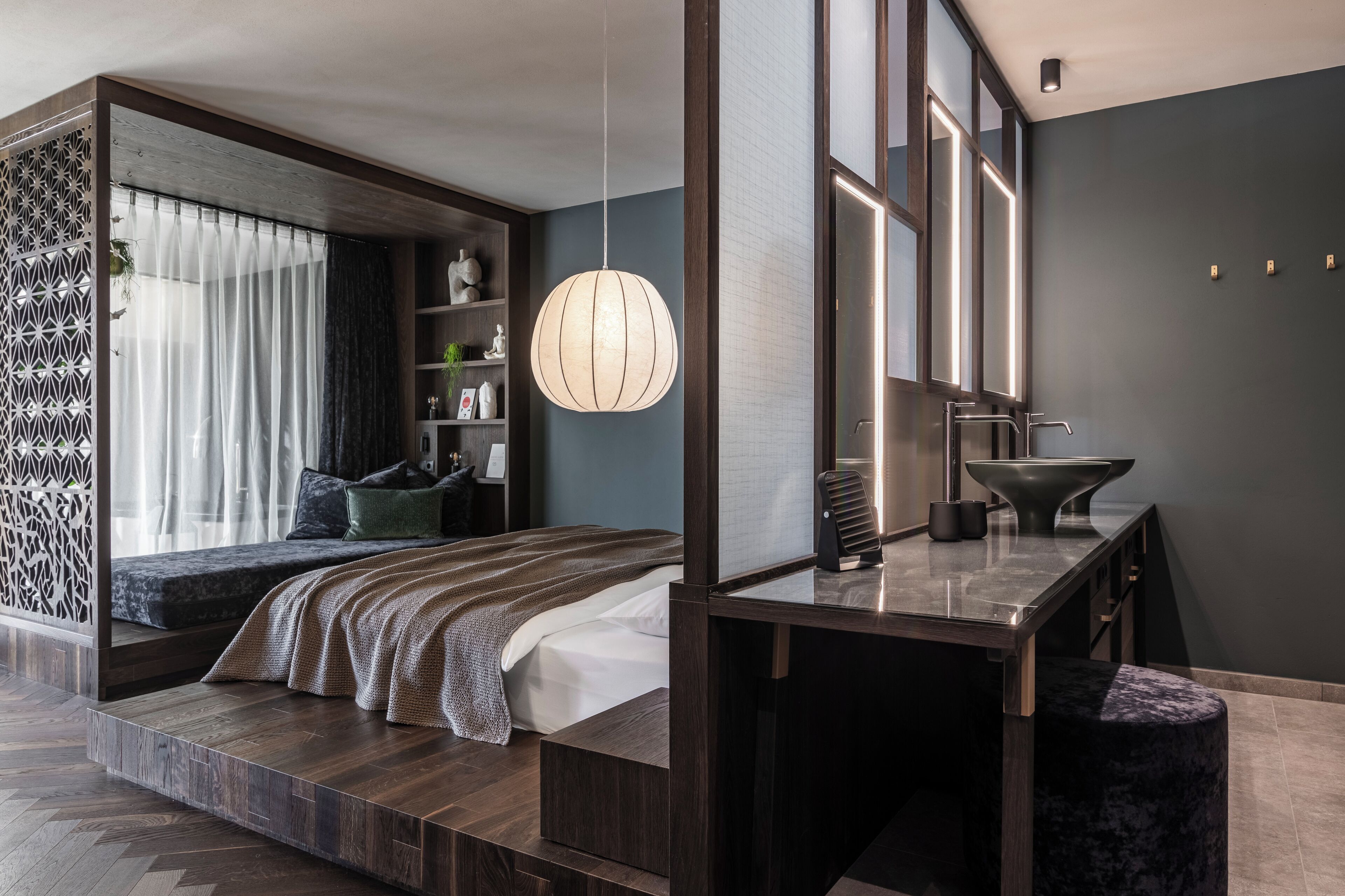 Un dormitorio moderno con cama, mesita de noche y un amplio ventanal.