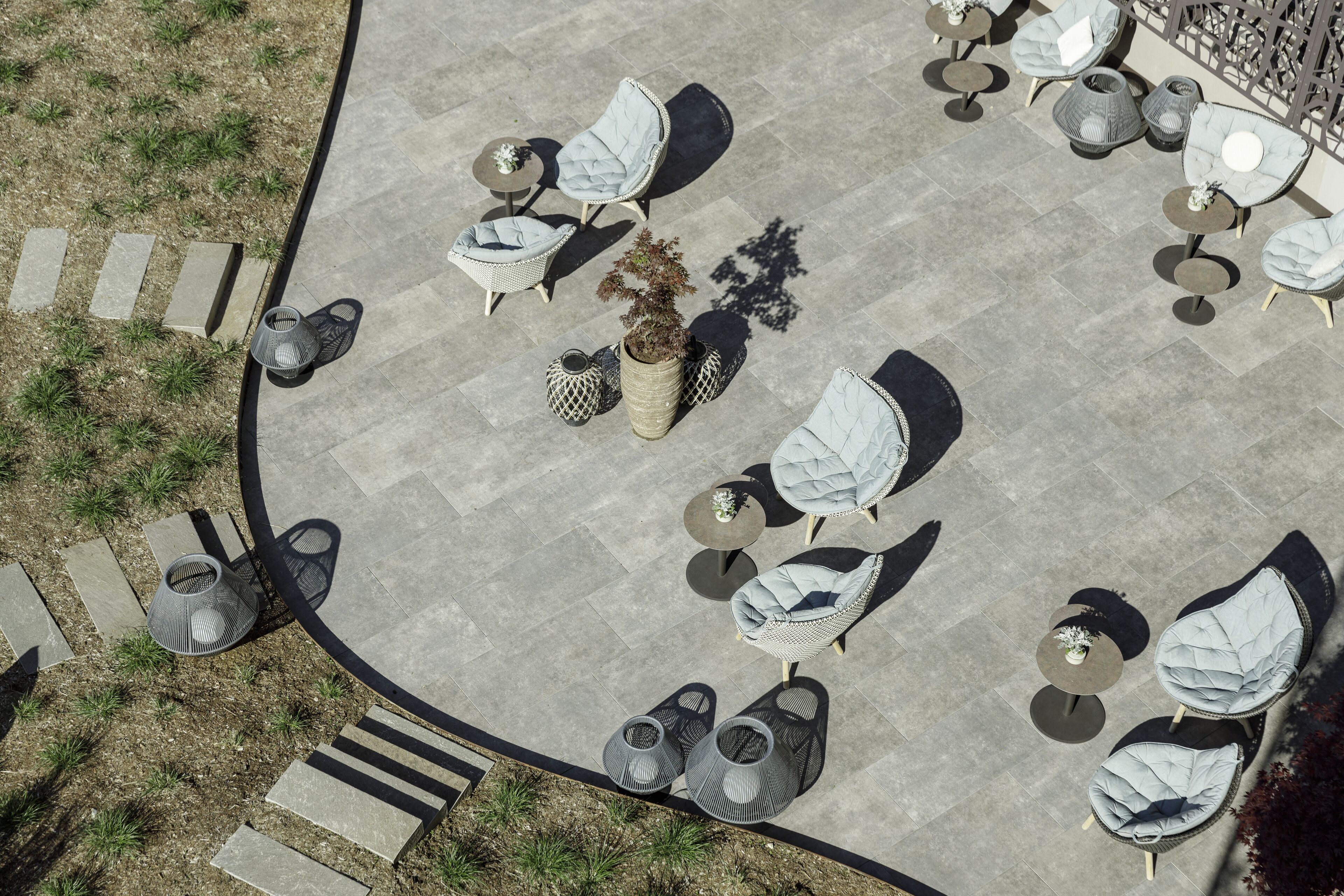 An outdoor seating area with multiple chairs and tables, arranged in a semi-circular pattern.