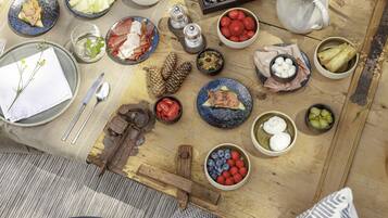 Un montaje para picnic con diversos alimentos y utensilios sobre una manta.
