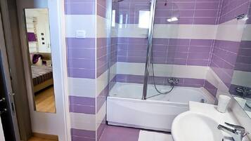 Un baño con bañera, ducha y lavamanos.