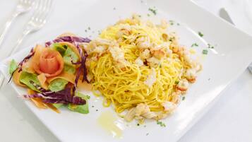 Eine Portion Spaghetti mit Garnelen und einem Salat.