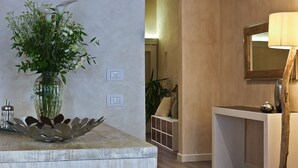 A modern bathroom with a white vanity, a mirror, and a vase of flowers on the counter. - Giglio Santa Trinita (Florence)