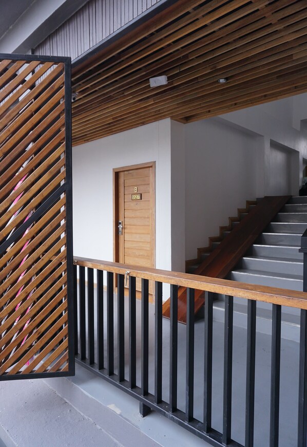 A staircase with wooden steps and a black railing, leading to a door marked with the number 927.