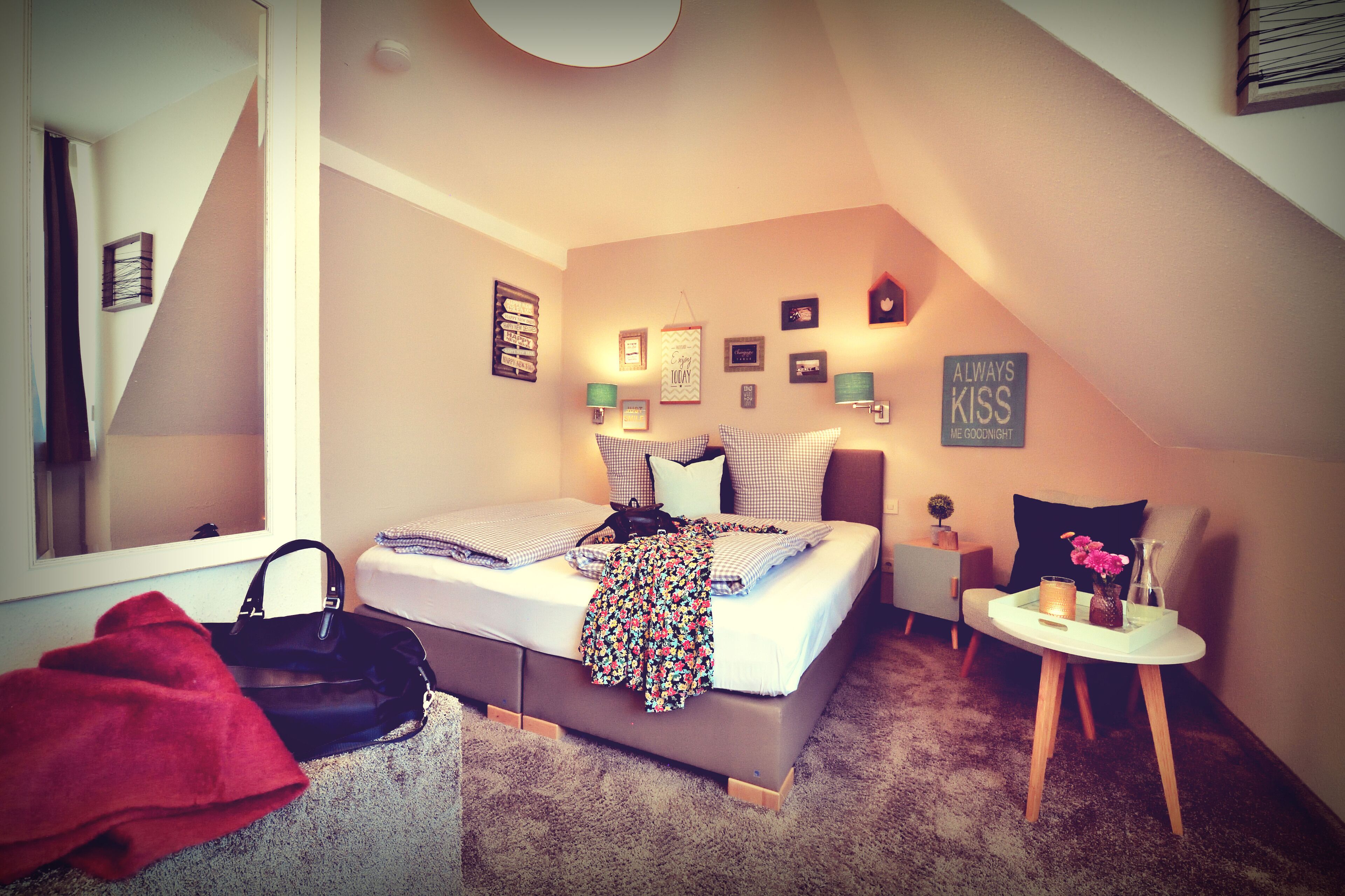 A bedroom with a bed, bedside table, and a small chair.