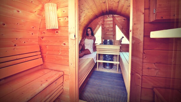 A wooden cabin with a bench, a small table, and a bench seat. - Melbo’s Home (Lindau)