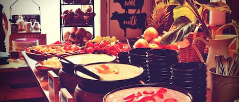 A buffet table with various dishes and a sign indicating dietary options.