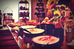 A buffet table with various dishes and a sign indicating dietary options. - Melbo’s Home (Lindau)