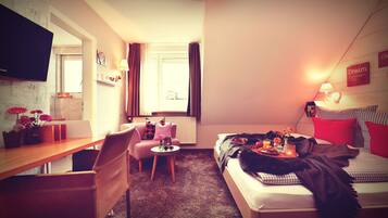Ein gemütliches Hotelzimmer mit Bett, Schreibtisch, Stuhl und Fernseher.