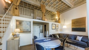 Amplia sala de estar con una mesa de comedor, un sofá y una escalera que sube a un nivel superior.